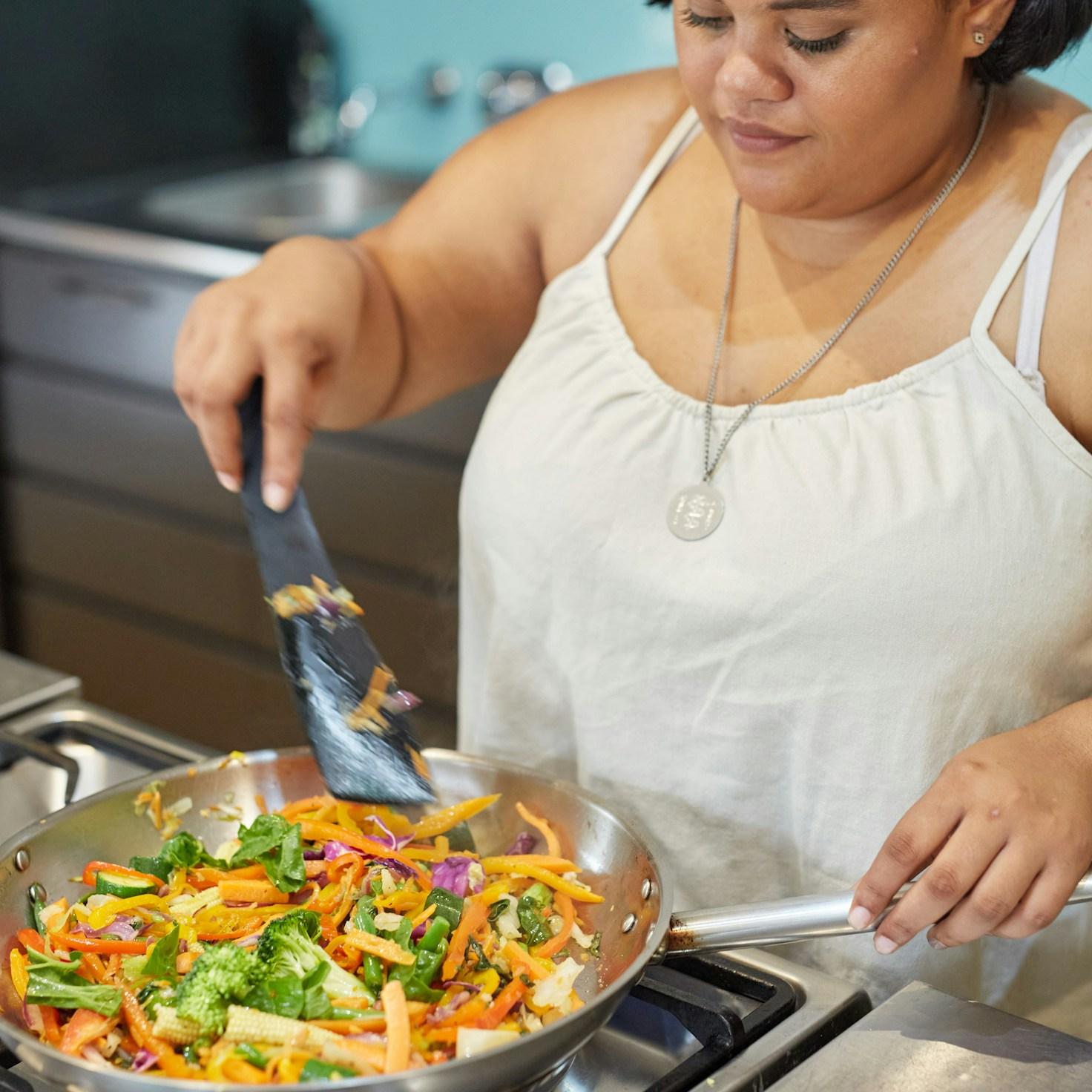 Community members working together in a contemporary kitchen, exchanging recipes and cooking techniques